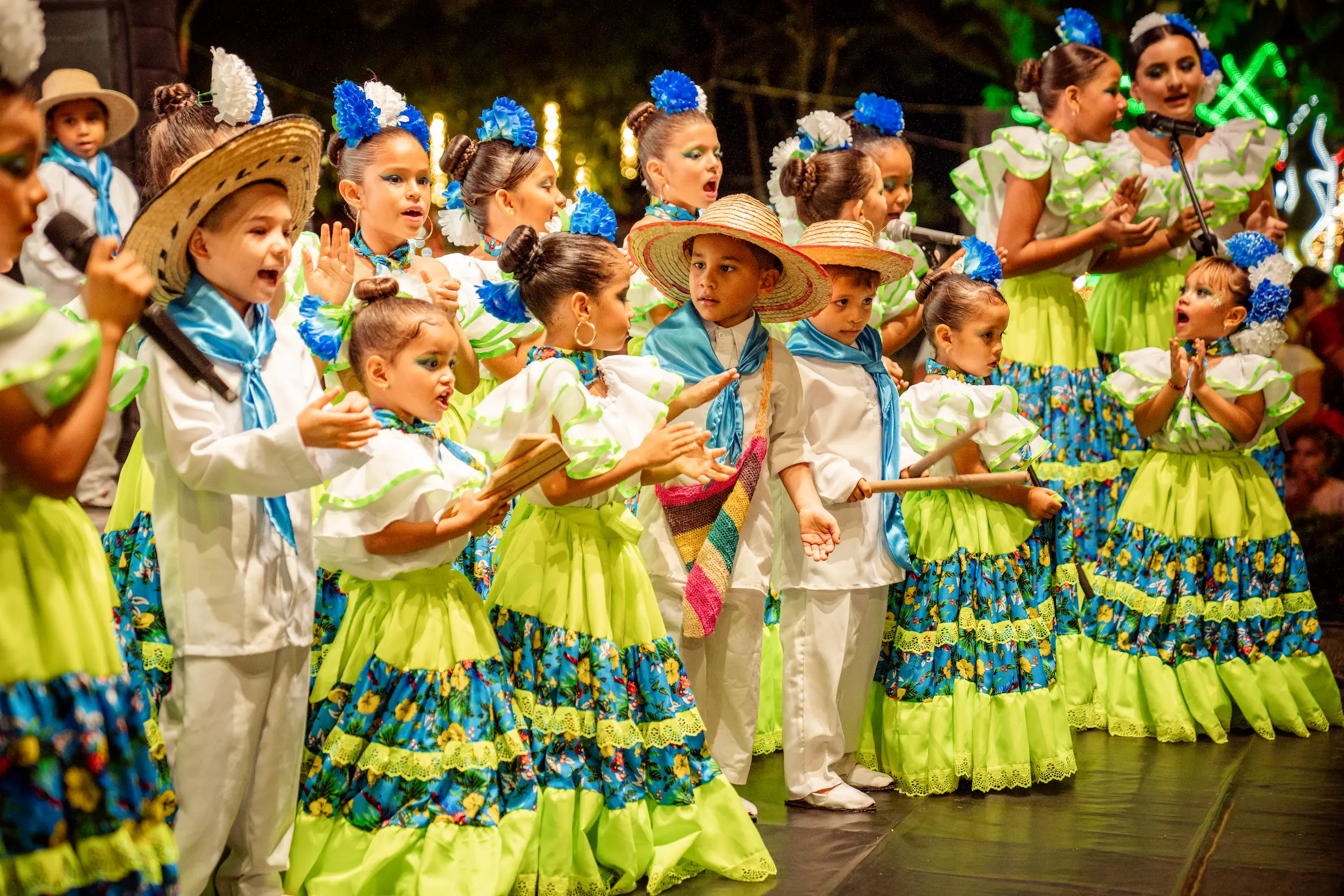 Grupo de baile tradicional de la Fundación El Chandé cantando en un festival nocturno.
