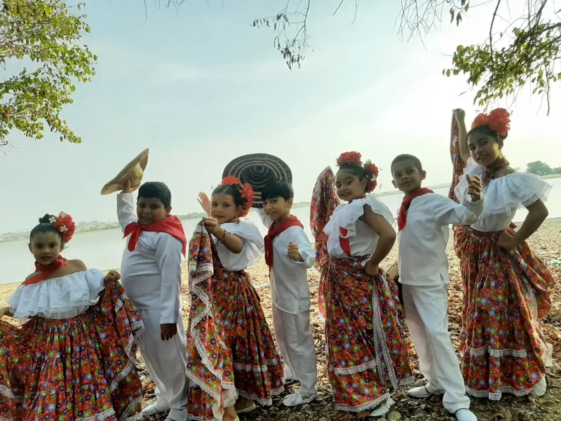 Primer plano de una Yohana Rios Rios con los ojos cerrados cantando con pasión, labial rojo y aretes dorados.